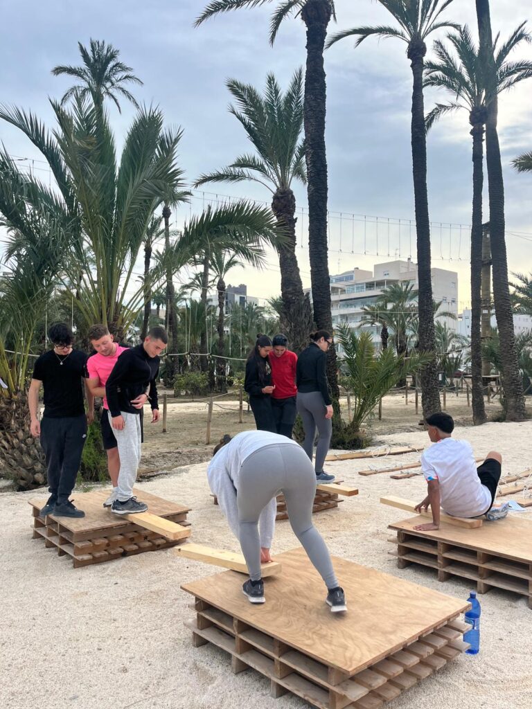 Grupo cruzando el paso de montaña sobre plataformas de madera en Multiaventura Elche